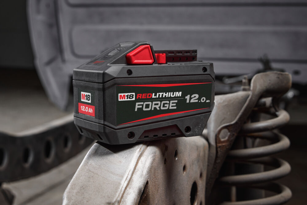 High-performance Milwaukee M18 FORGE 12.0 Ah battery pack on a truck suspension assembly.